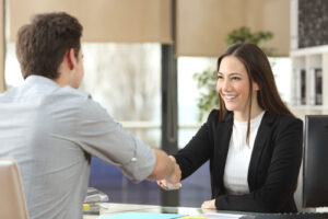 Man and woman shaking hands in a business meeting.